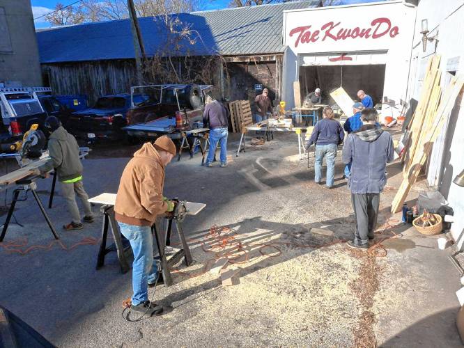 Greenfield Tae Kwon Do Center instructors and members help cut planks into smaller boards for the center’s annual “Break-athon” fundraiser for Warm the Children.