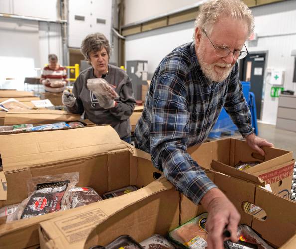 Andrea Leibson and Tom Rees, volunteers at the Food Bank of Western Massachusetts, sort and pack frozen meat to be distributed at one of the nonprofit’s many mobile food bank locations. Food insecurity has risen to pre-pandemic levels throughout the region. 