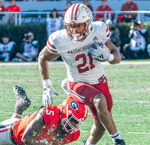 UMass running back Jalen John (21) avoids Georgia linebacker Raylen Wilson (5) during the Minutemen’s 59-21 loss to the Bulldogs on Saturday afternoon at Sanford Stadium in Athens, Ga.