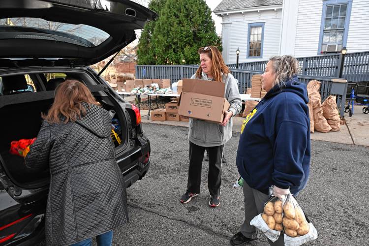 Jodi Bonin and Barbara Viencek help Claudia Hernandez of ServiceNet, left, pick up meals for families at the Bernardston Senior Center on Friday afternoon.