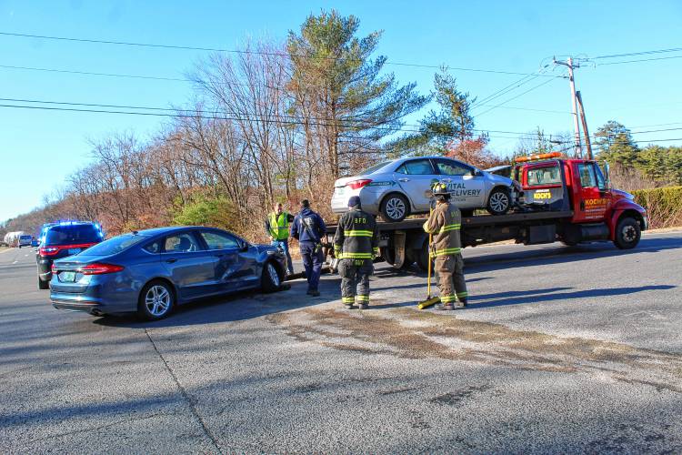 Members of the Bernardston Police and Fire departments clear debris from Route 10 after a two-car collision sent an elderly man to Baystate Franklin Medical Center in Greenfield on Monday.