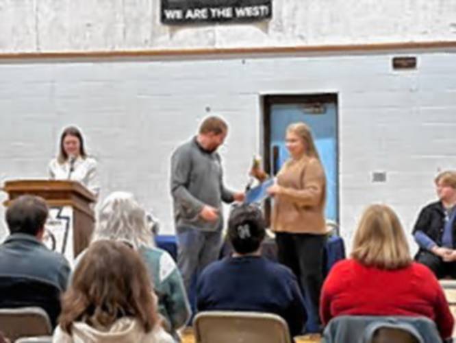 Alison George, right, receives her certificate from faculty advisor Brett Erelli inducting her into Franklin County Technical School’s chapter of the National Honor Society. Taryn Canfield, faculty advisor, is at the podium.