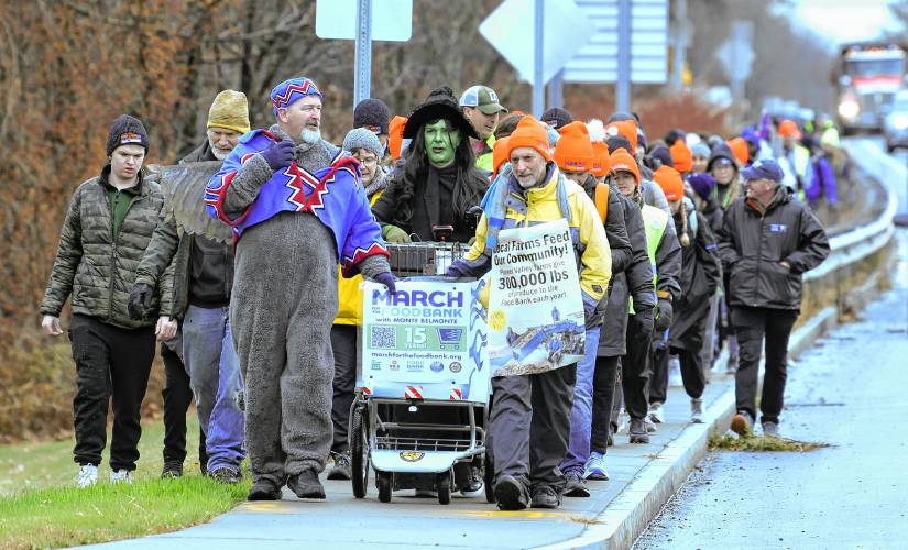 The March for the Food Bank with Monte Belmonte, dressed as the green-faced witch from “Wicked,” makes its way up Greenfield Road (Routes 5 and 10) in Deerfield on Tuesday. Walking next to Belmonte, dressed as a flying monkey, is Sean Barry.