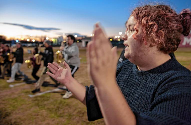 Julia Alo claps to keep time for the alto sax section of the UMass marching band while practicing for the Macy’s Thanksgiving Day Parade.