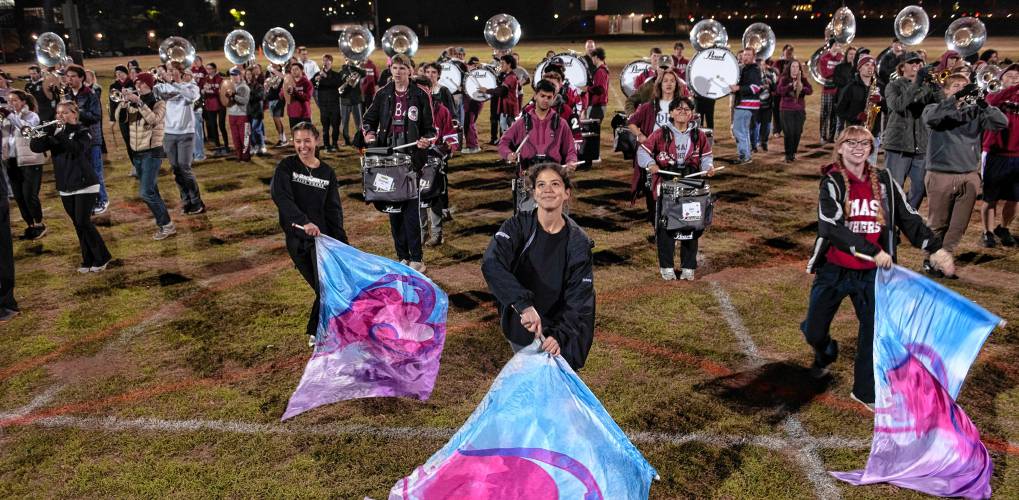 Olivia Fuoti, left, Brianda DeLeon, middle and Audrey Brecher, right, members of the UMass marching band, practice with about 400 other band members for the Macy’s Thanksgiving Day Parade.