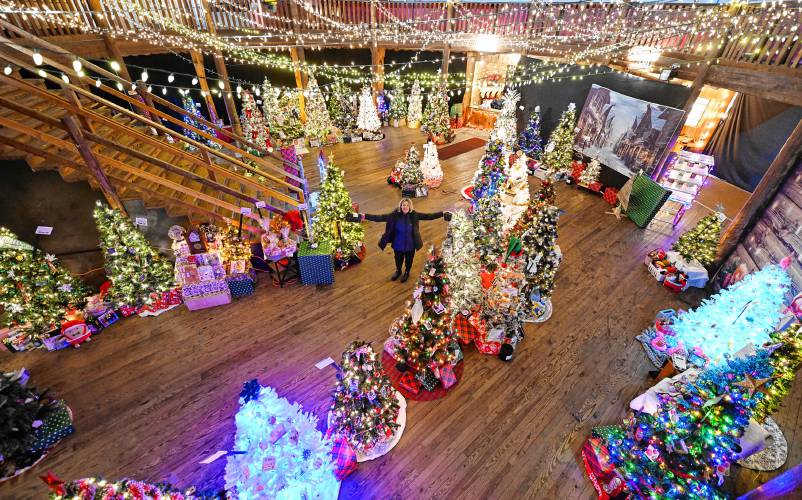 April Healey, who helps organize the Festival of Trees, with the decorated trees displayed at the Roundhouse at the Franklin County Fairgrounds in Greenfield.