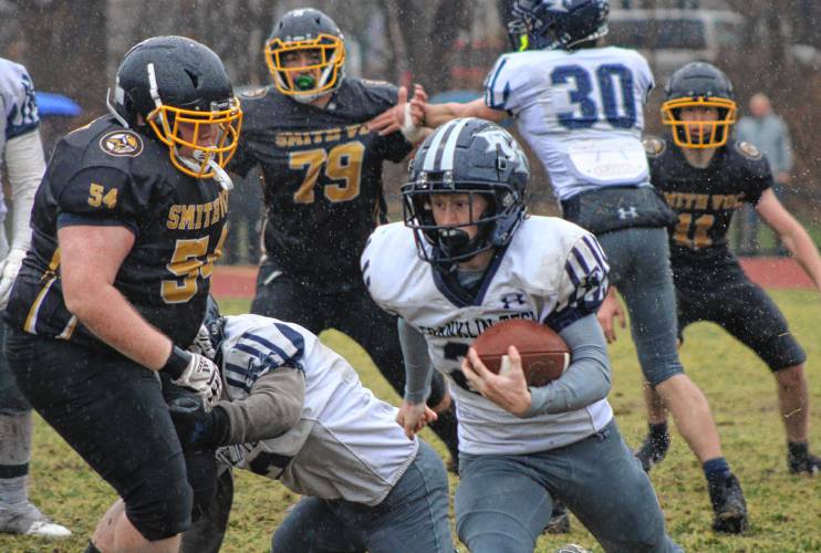 Franklin Tech’s Josiah Little carries the ball under pressure from Smith Vocational’s Jayden Yon (54) during the Vikings’ 16-8 overtime win on Thursday at Mountain View School in Easthampton.