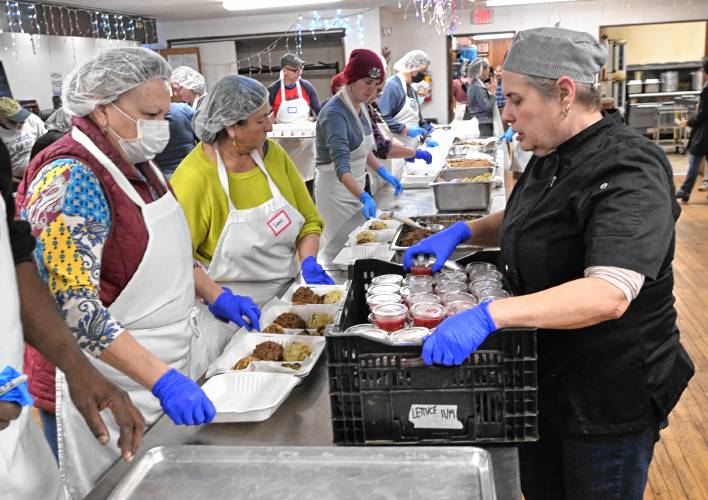 Kirsten Levitt, executive director and chef of Stone Soup Cafe, right, helps workers pack up meals on Thanksgiving in Greenfield. 