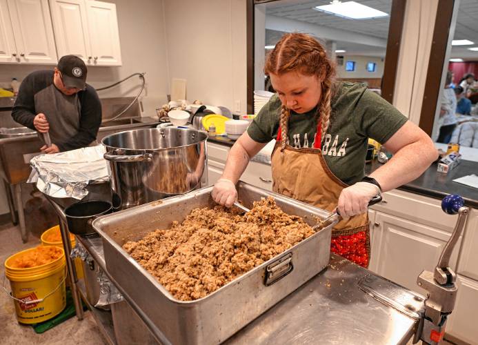 Volunteer Bella Cooke of Royalston mixes up the stuffing at the free community meal put on at Athol American Legion Post 102 on Thanksgiving. 