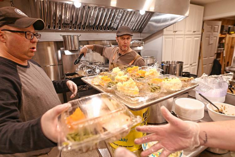 Volunteers Eric Jack and Don Eaton box up food to go at the free community meal put on at Athol American Legion Post 102 on Thanksgiving. 