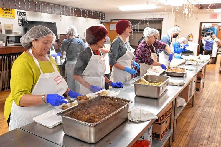 Staff and volunteers help pack up hundreds of meals, including vegan and traditional turkey, at Stone Soup Cafe on Thanksgiving in Greenfield. 