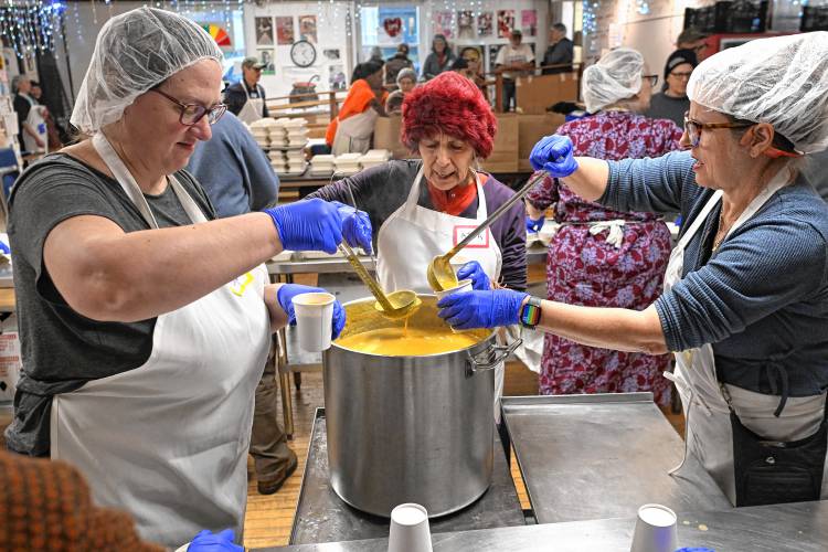 Workers fill cups of soup at Stone Soup Cafe on Thanksgiving in Greenfield.