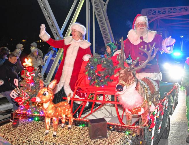 Mrs. Claus and Santa cross the Iron Bridge during the Parade of Lights at Moonlight Magic in Shelburne Falls on Friday night.