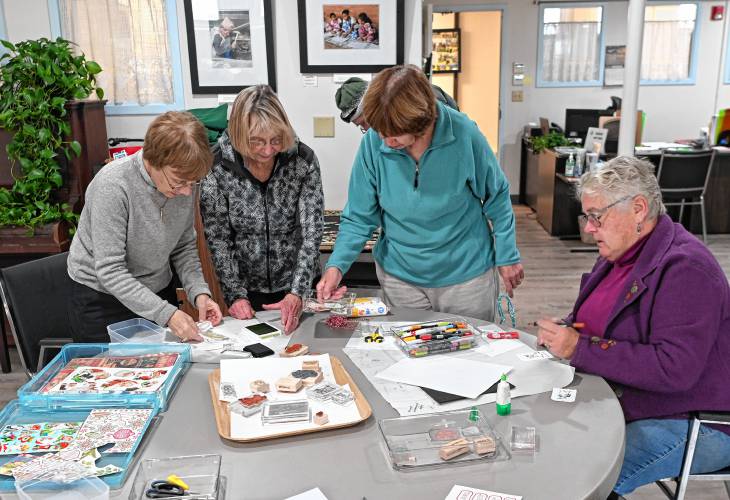 From left, Debby Wiesen Kelly is assisted by Barbara King, along with Chris Harris and Pam Eldridge, during a workshop on crafting tags for holiday gifts held at the Northfield Senior Center on Tuesday.