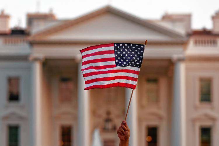 A flag is waved outside the White House, in Washington, D. C.