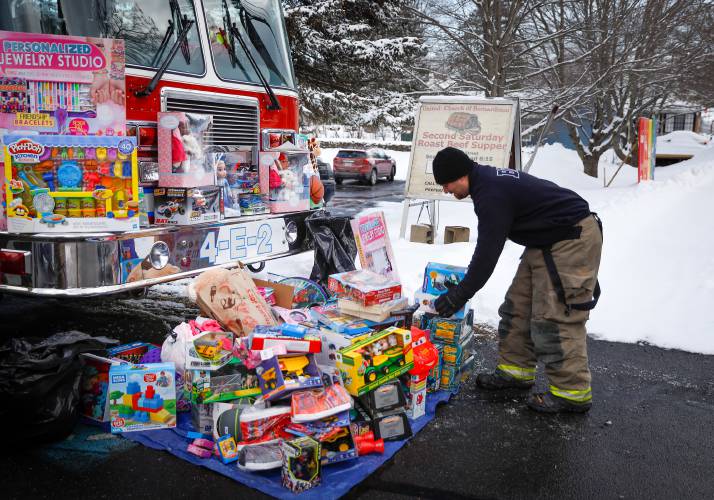 Jake Tokarz places a donation on the pile during the 2019 Bernardston Police and Fire departments’ annual toy drive at the United Church of Bernardston.