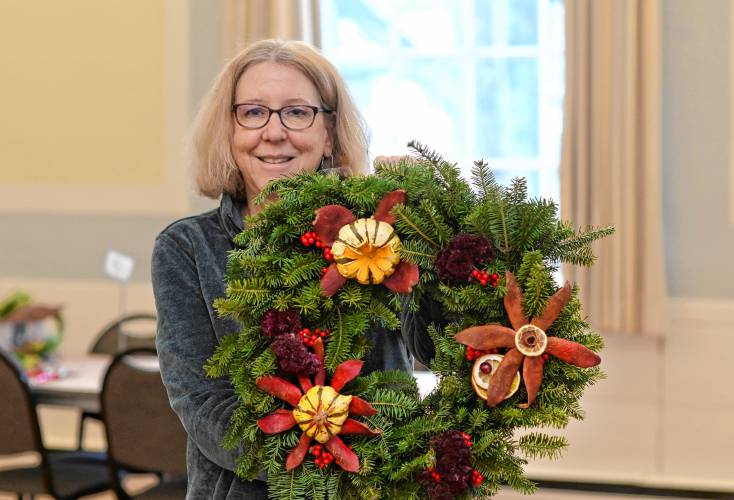 Northampton resident Louise Lucht holds the wreath she made during the Historic Deerfield wreath-making workshop on Tuesday.