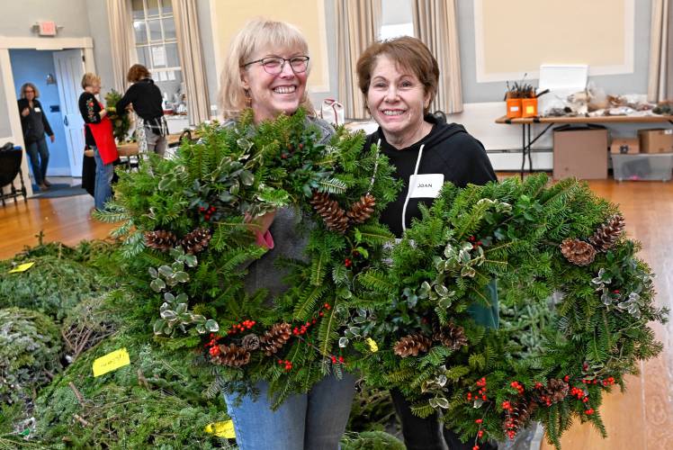 Greenfield resident Ruth Odom and Shelburne resident Joan Knox hold the holiday wreaths they made during the Historic Deerfield wreath-making workshop on Tuesday.