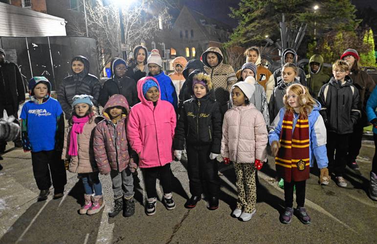 Children sing holiday songs at Veterans Mall during the first night of Jingle Fest in Greenfield on Friday night.