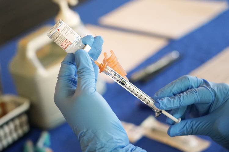 A nurse prepares a syringe of a COVID-19 vaccine at an inoculation station in Jackson, Miss., July 19, 2022.