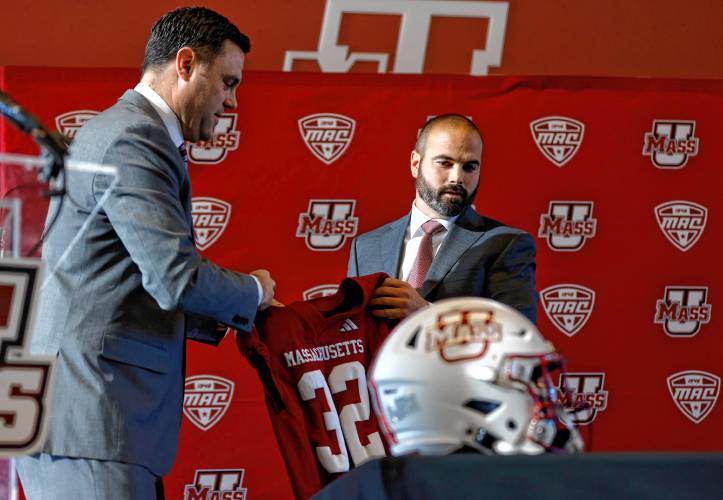 Joe Harasymiak, right, receives a jersey from Athletics Director Ryan Bamford as the 32nd UMass head football coach on Friday during a press conference at the Martin Jacobson Football Performance Center in Amherst.