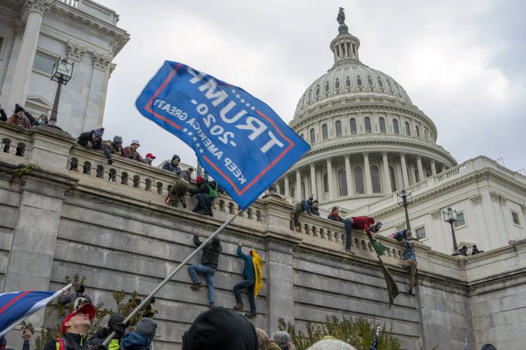 Supporters of President Donald Trump climb the West wall of the the U.S. Capitol, Jan. 6, 2021, in Washington.